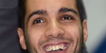 Jeune homme souriant, visage expressif, regard direct, cheveux courts, peau claire.