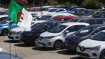 Parc automobile en Algérie avec drapeau national algérien.