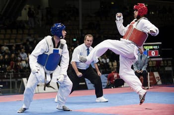 Deux athlètes de taekwondo en action lors d'un match international.