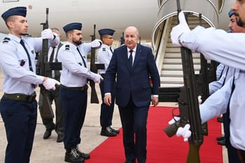 Homme d'État saluant des soldats lors d'une visite officielle.