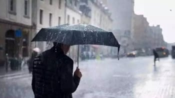 Personne avec parapluie sous forte pluie en ville.