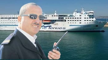 Homme en uniforme de capitaine avec ferry en arrière-plan.
