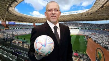 Hafid Derradji avec un ballon de football dans un stade vide.