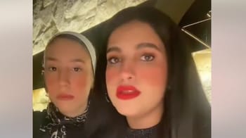Deux femmes, l'une voilée, exprimant leur opinion dans un restaurant.