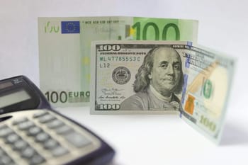 Billets de 100 euros et 100 dollars avec calculatrice.