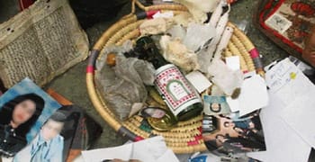 Objets de sorcellerie et photos dans un panier à Cheraga.