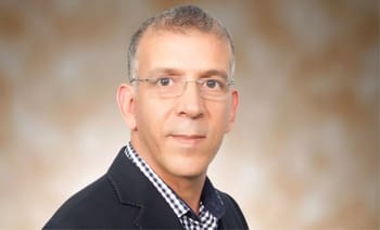 Portrait d'un homme professionnel portant des lunettes et un costume.