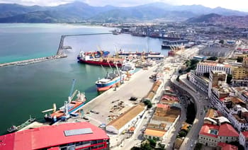 Vue aérienne d'un port en Algérie avec navires et infrastructures portuaires.