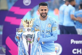 Mahrez souriant tenant la coupe de la Ligue des Champions.