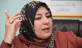 Naïma Salhi au tribunal, portant un hijab noir et un manteau marron.