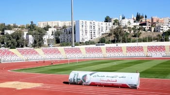 Stade de Constantine avec piste d'athlétisme et sièges rénovés.
