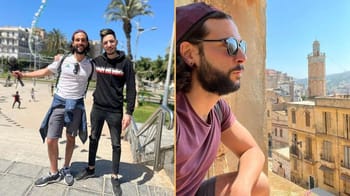 Deux hommes profitent du soleil à Oran, vue sur la ville et la mer.