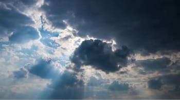 Ciel nuageux avec rayons de soleil perçant à travers les nuages.