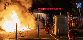Pompiers éteignant un feu lors d'une manifestation nocturne en France.