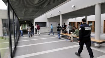 Policiers et personnes dans un hall d'entrée en France.