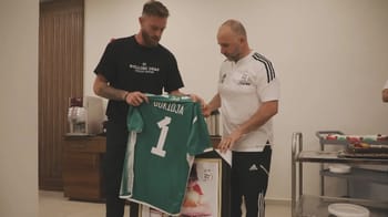 Alexandre Oukidja reçoit un maillot de football lors d'une cérémonie.