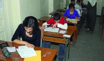 Étudiants passant un examen dans une salle de classe.
