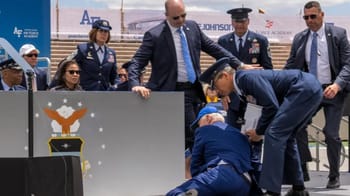 Le président Biden tombe lors d'une cérémonie militaire, entouré de militaires et de civils.