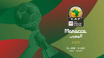 Trophée de la Coupe d'Afrique U23 avec drapeau marocain en arrière-plan.