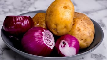 Pommes de terre et oignons dans un bol, produits agricoles courants en Algérie.