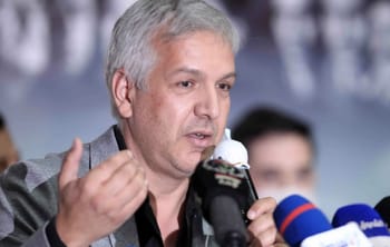 Djaffar Gacem parlant à une conférence avec microphones.