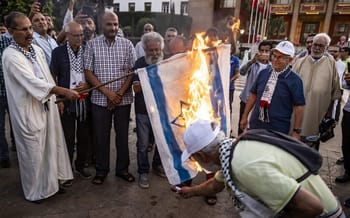 Manifestants brûlant un drapeau israélien lors d'une protestation au Maroc.