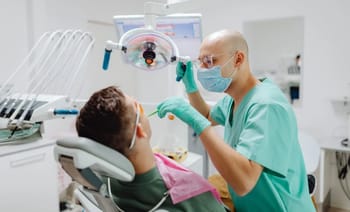 Dentiste administrant une anesthésie à un patient en cabinet dentaire.