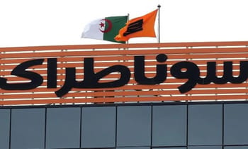 Drapeaux algérien et angolais flottant au-dessus d'un bâtiment Sonatrach.