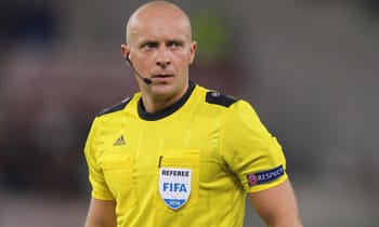 Arbitre de football en tenue jaune lors d'un match important.