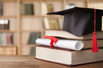 Chapeau de diplômé et livres pour la réussite scolaire.