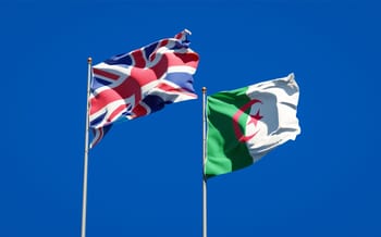 Drapeaux du Royaume-Uni et d'Algérie flottant dans le ciel bleu.