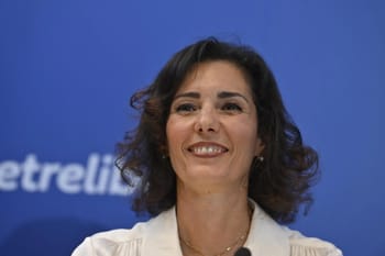 Femme souriante lors d'une cérémonie diplomatique en Algérie.