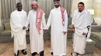 Cinq hommes en vêtements traditionnels saoudiens et africains lors d'une réunion.