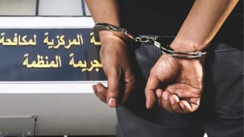 Suspect en garde à vue avec menottes lors d'une opération policière.