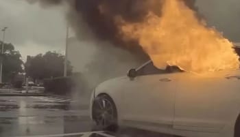 Voiture en feu lors d'une tempête orageuse.