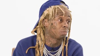 Rappeur avec dreadlocks et tatouages, expression surprise.
