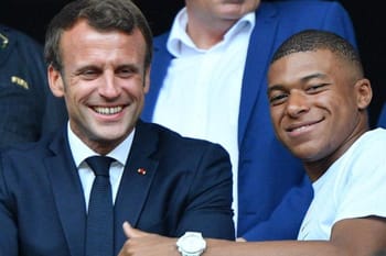Emmanuel Macron et Kylian Mbappé souriants lors d'une rencontre officielle.