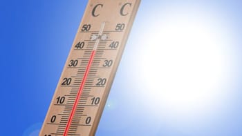 Thermomètre indiquant 44°C sous un ciel ensoleillé.