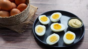 Œufs durs coupés en moitiés avec sauce dans une assiette noire.