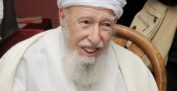 Portrait de l'érudit Mohamed Tahar Aït Aldjet âgé et souriant.