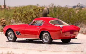 Voiture Ferrari vintage rouge en vente dans un paysage désertique.
