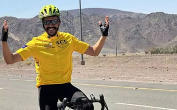 Cycliste en route vers La Mecque, portant un casque jaune et un maillot jaune.