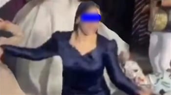 Jeune fille en robe bleue qui danse avec énergie lors d'une fête.