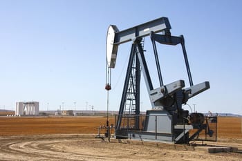 Puit de pétrole en activité dans un paysage désertique.