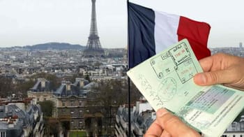 Passeport et titre de séjour avec la Tour Eiffel en arrière-plan.