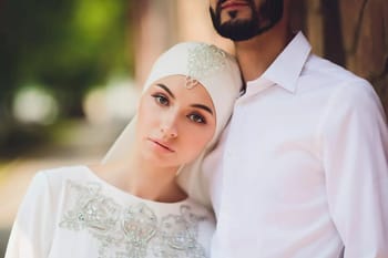 Jeune femme en hijab et homme en chemise blanche, couple interculturel.