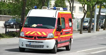 Véhicule de secours rouge avec sirènes en service.