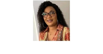 Femme souriante portant lunettes et vêtue d'une robe colorée.