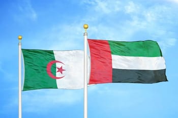 Drapeaux de l'Algérie et des Émirats arabes unis flottant dans le ciel bleu.