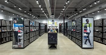 Magasin de chaussures avec rayons bien organisés et affiches promotionnelles.